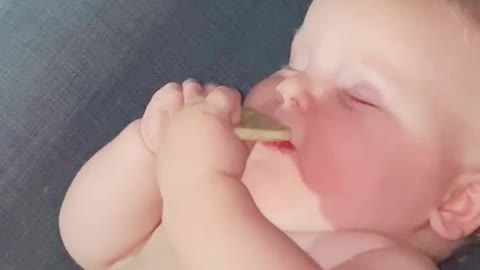 Tired Baby Eats A Cookie While Half Asleep