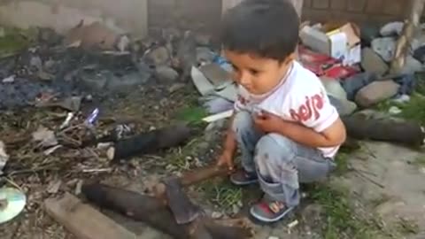 Very Small boy Playing with Axe