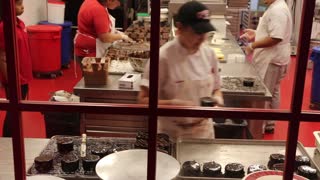 Putting chocolate on cakes at Carlos cake factory at The Venetian in Las Vegas.