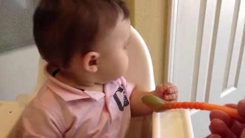 Cute baby doesn't want to eat his peas.