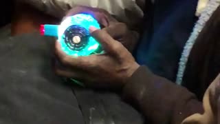 Man holds weird glowing blinking device on subway