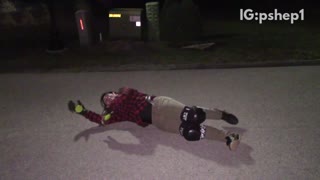 Plaid helmet guy falls off skateboard at night and hits head on sidewalk