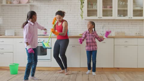 Mother and daughters in a kitchen dancing amazing