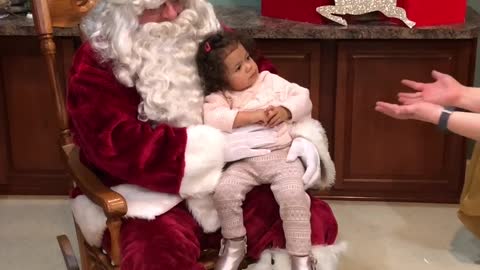 Little girl refuses to leave Santa's lap