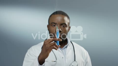 Close Up Of The Young Man Physician Or Intern Holding A Syringe With A Needle And Withdrawing Fluid
