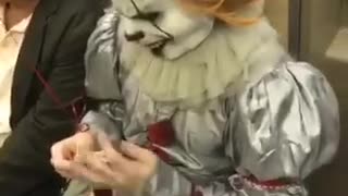 Pennywise clown costume knitting subway train sit