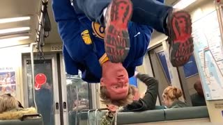 Drunk man with golden state warriors shirt holds onto subway handrails and does backflip