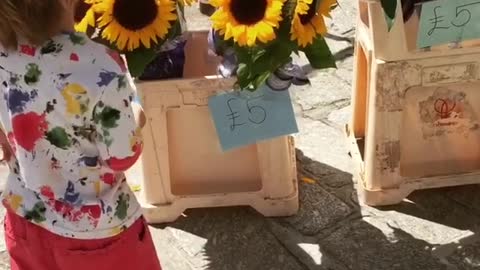 Gorgeous little boy buys flowers for his mum