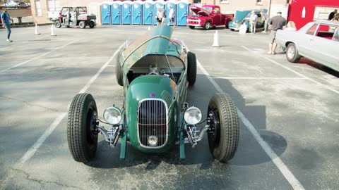 A Green Vintage Automobile With An Open Hood Parked