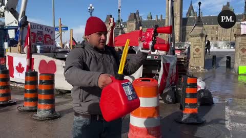 A Freedom Convoy supporter in Ottawa drinks Gatorade from a jerrycan