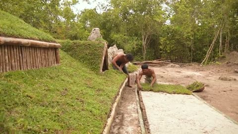 Building underground hut with grass roof & fireplace with clay