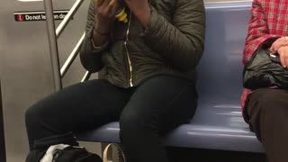 Woman eats purple cabbage with mustard on subway train
