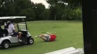 Red shirt grey shorts golfer hit by golf cart