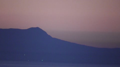 A mountain range in pink mist