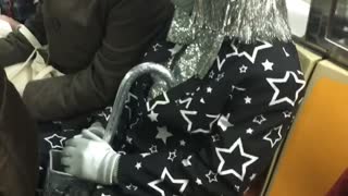 Woman in black and silver star tuxedo on subway train