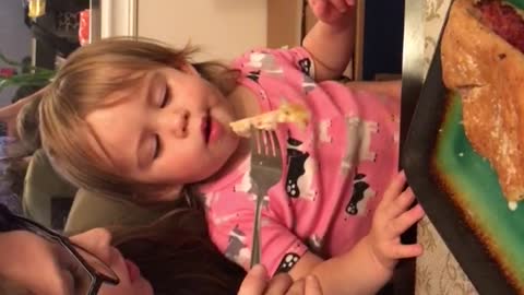 Cute toddler trying to cool her food down