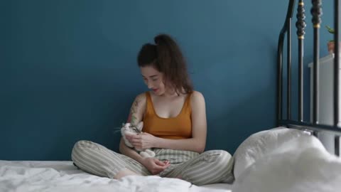 Young beautiful Asian woman relaxing and playing with her lovely cat