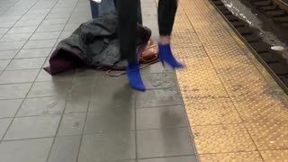 Woman has headphones on and happily dances by herself in subway station