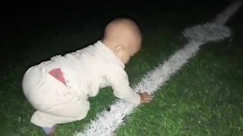 Funny little kid playing on the soccer field