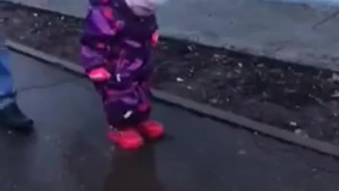 a child plays in a puddle