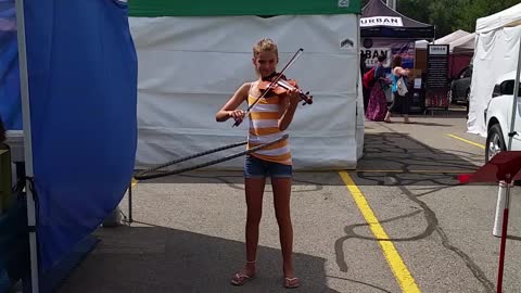 Talented girl plays violin while hula-hooping