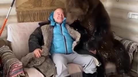 A bear caresses this man ,can't believe m'y eyes