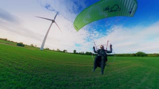 Paramotor Flies Around Wind Turbine