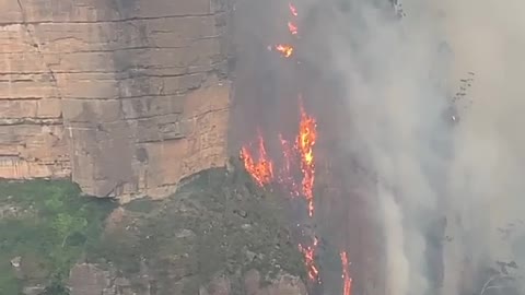 Fire in Australia filmed hugging cliffside like 'lava waterfall'