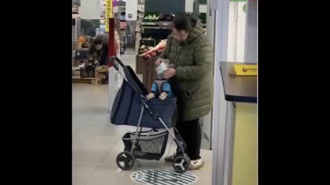 Woman put a mask to her dog at the mall.