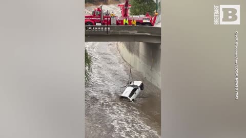 L.A. Firefighters Dangle from Bridge to Retrieve Car Swept Away by Tropical Storm Hilary