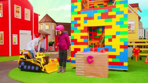 The kids build a Lego tower with a real construction vehicle