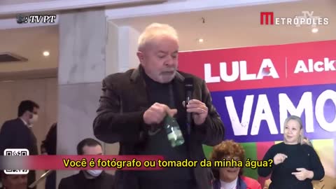 Fotógrafo tenta tirar garrafa de água das mãos de Lula e ex-presidente o repreende