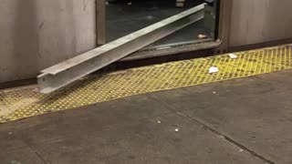 Man carries a metal beam on subway train