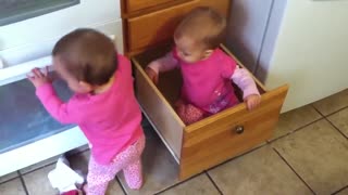 Two twins playing in the kitchen