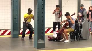 Guy yellow shirt dancing to violin duo subway