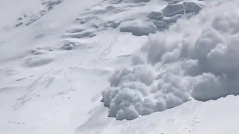 Massive avalanche rolls down the side of a cliff!