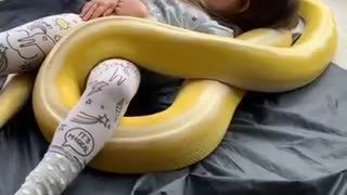 Little girl shilling with snake