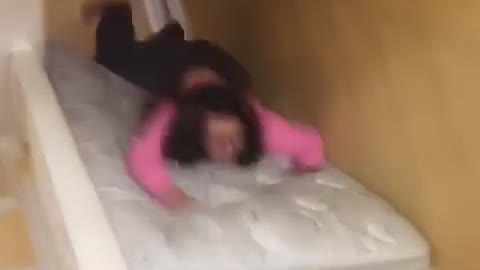 Girl pink shirt glasses mattress stair slide fail face plant