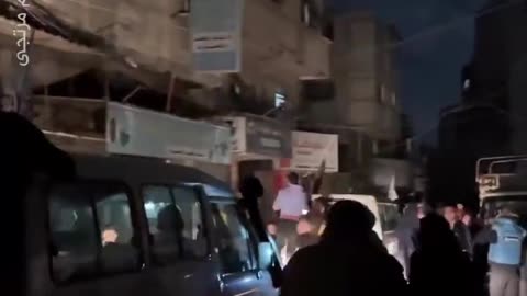 Palestinian civilians climbing on the cars taking the hostages to the border.
