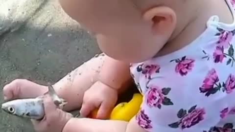 Funny baby playing with fish
