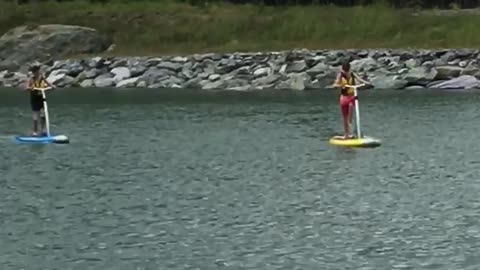 Two people on paddle boards in lake