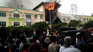 Fireman attempt to put out flames on burning building