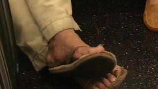 Zooming in on a mans toe nails on subway train