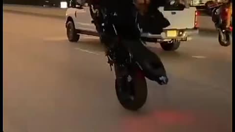 see woman doing radical maneuver with motorcycle