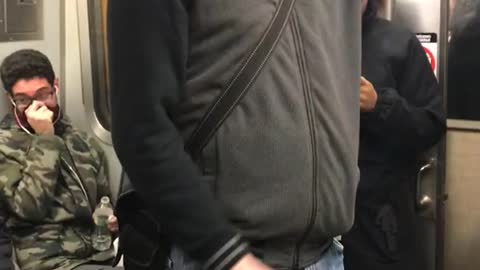 Guy smokes in the middle of subway train after being told by passengers not to