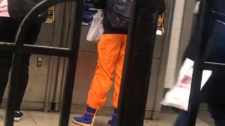Guy wears orange ninja pants at subway station ticket booth