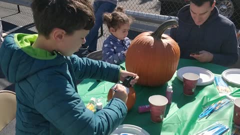 Spencer painting a pumpkin at Merrick Fire Station fall event VID 20191005 111159