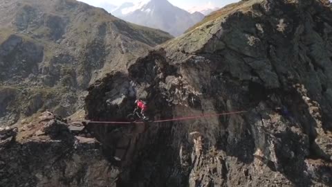 World champion rides bike over slackline in the Alps