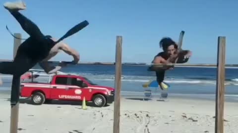 Men Perform Calisthenics Swing 180 on Bars At Beach