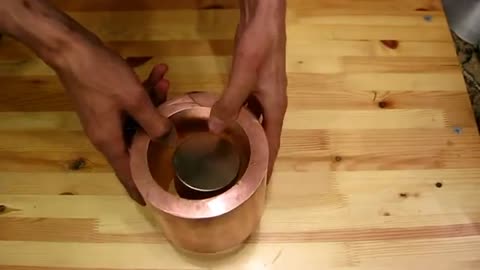 What happens when a magnet passes through a copper cylinder